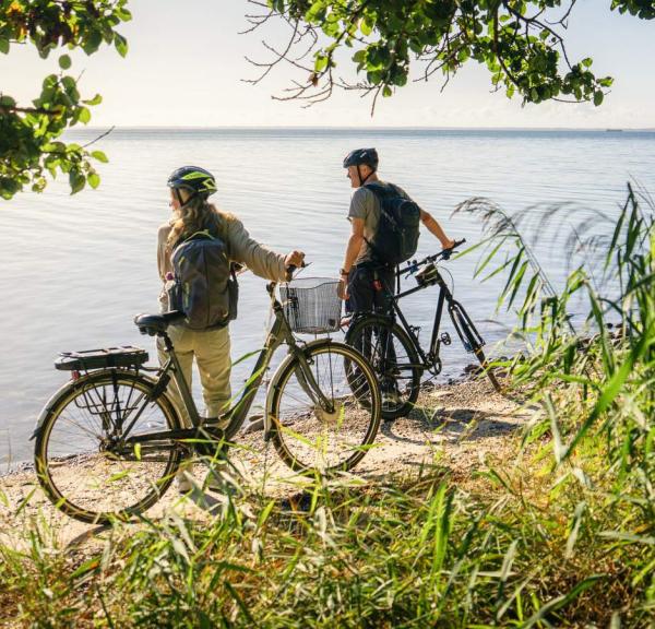 Par på cykelferie betragter kysten