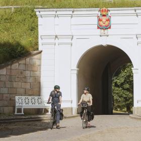 Par på cykelferie cykler igennem Prinsens Port i Fredericia
